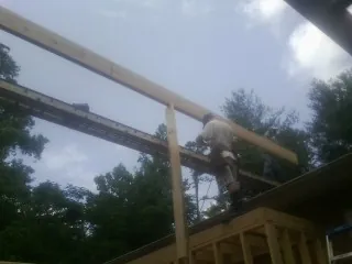 Carpenter setting a ridge beam over a new addition frame — Ice Dam Removal by Roofing Brothers in Francitas
