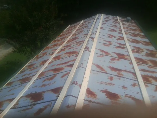Rusted metal roof panels with new wood purlins before replacement — Storm Damage Roof Repair in Francitas by Roofing Brothers