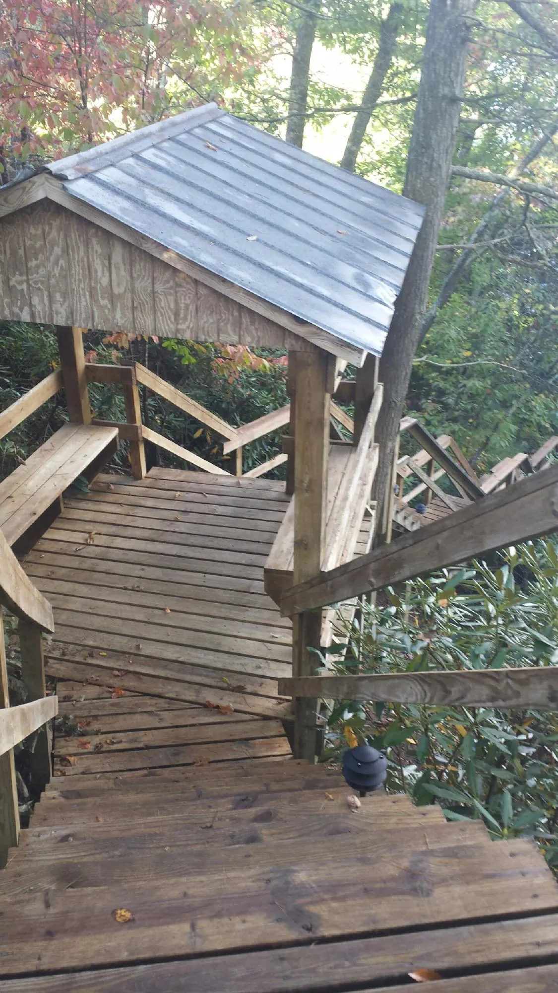 Metal roofed shelter over wooden steps on a wooded walkway — Skylight Repair & Installation work by our crew in Francitas