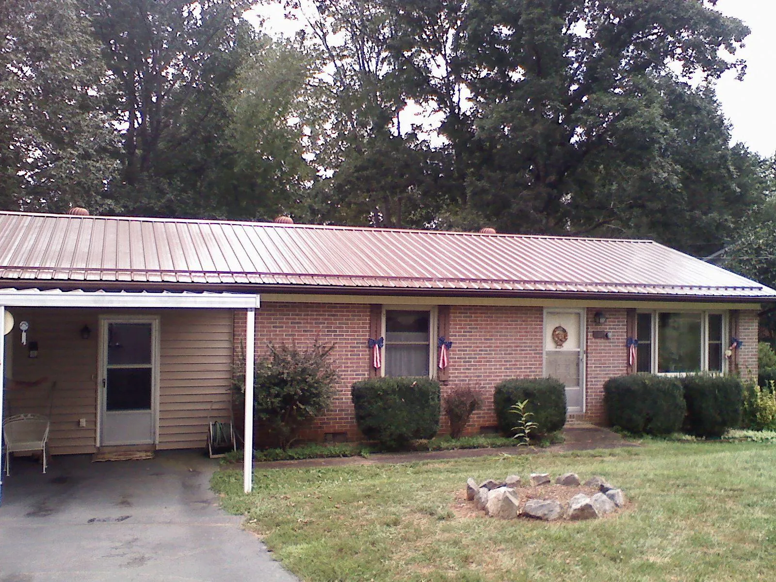 Bronze metal roof and carport on a brick ranch home — Roof Repair work by our crew in Francitas
